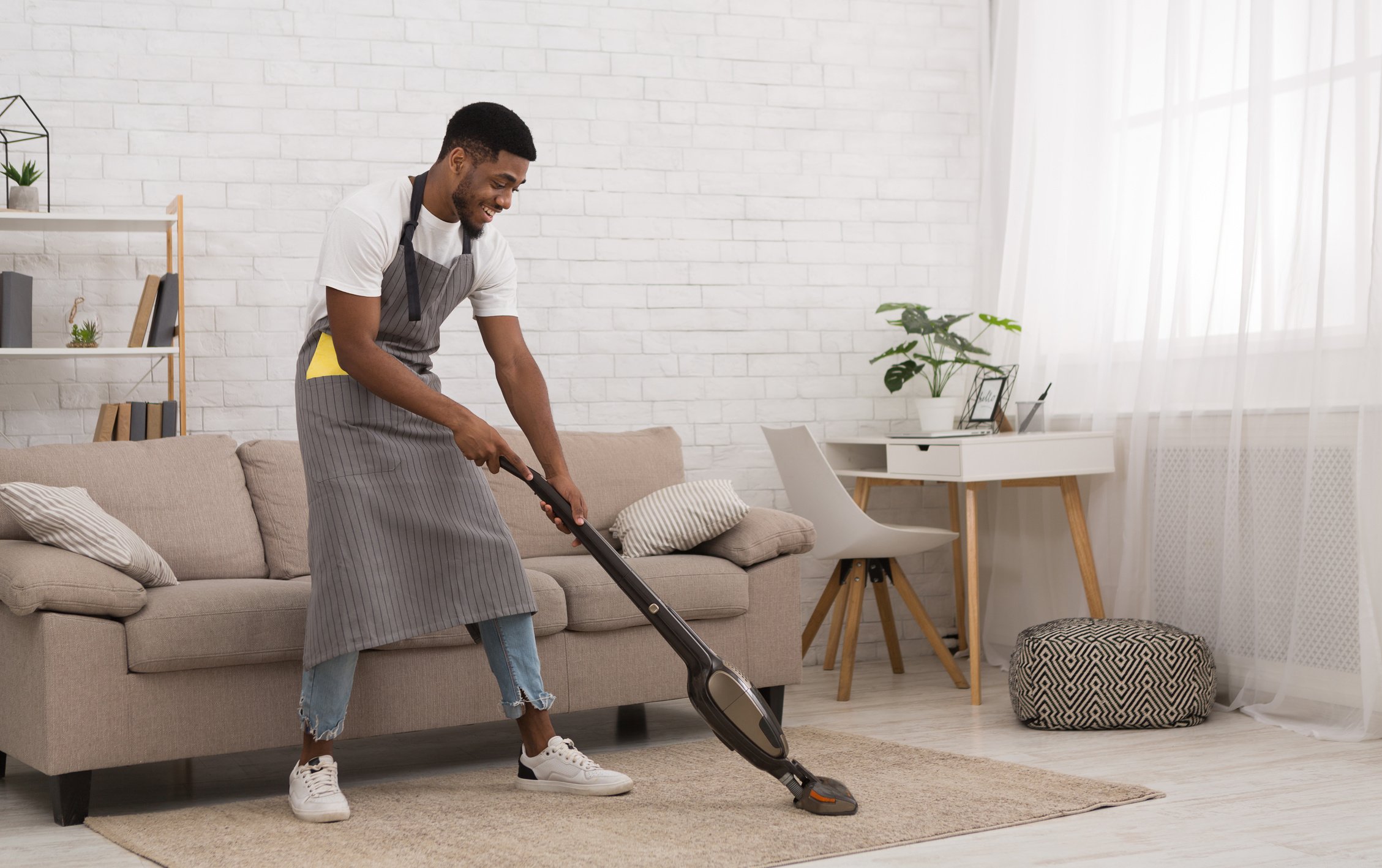 Man Cleaning a Carpet with a Vacuum Cleaner 